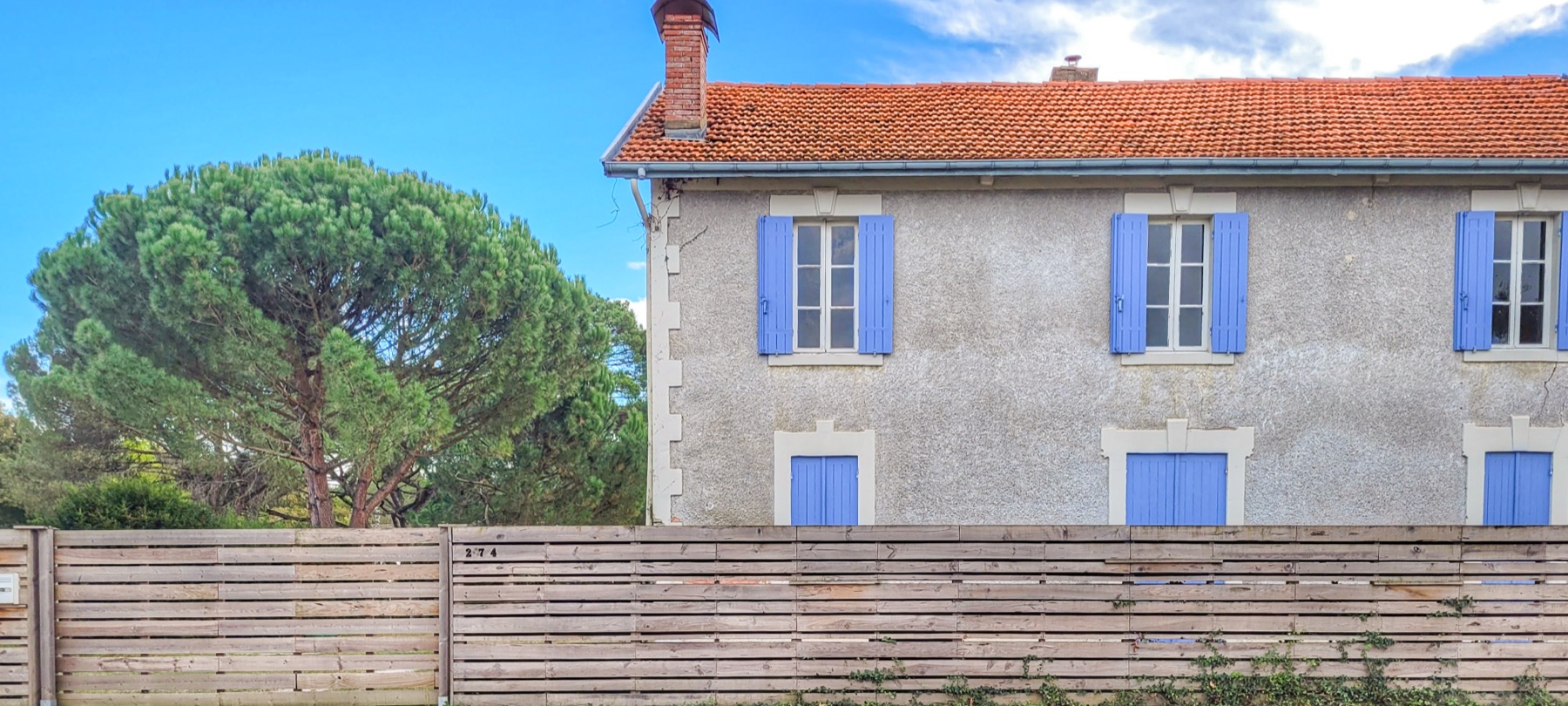 Façade rue volets bleus toit tuile